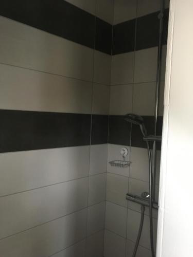 a shower with a black and white stripe at Gite de sejour la grange de Théophile in Anzin-Saint-Aubin