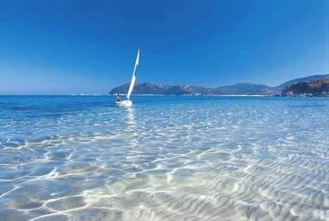 a sail boat in the water on a beach at Costa vacanze in low cost - IUN P2923 in Villaputzu