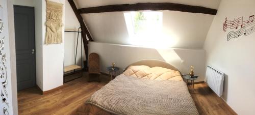 um pequeno quarto com uma cama no sótão em Gite de sejour la grange de Théophile em Anzin-Saint-Aubin