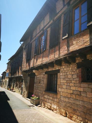 an old brick building with windows on a street at Castel Mazars in Castelnau-de-Montmiral