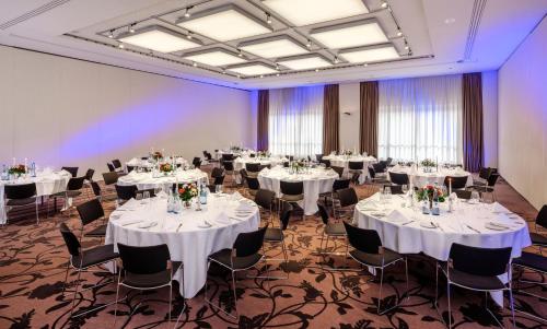 a banquet room with white tables and chairs at Dorint Hotel Bremen in Bremen