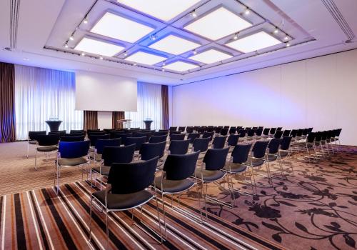 a large room with chairs and a screen in it at Dorint Hotel Bremen in Bremen