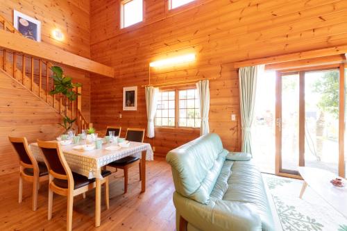 a dining room with a table and a couch at Keiko's Home Beautiful Resort Villa 20 min to Tenjin free park in Itoshima