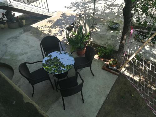 a patio with a table and chairs and a potted plant at Tbilisi guesthouse Nini in Tbilisi City