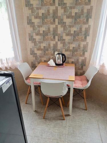 a table and chairs with a tea kettle on it at Sweet Home at Ninoshvili 3 in Batumi
