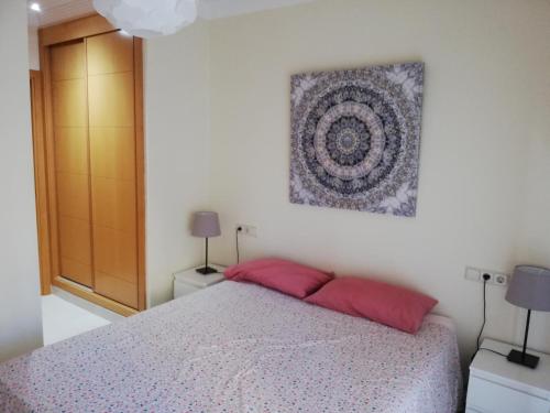 um quarto com uma cama com duas almofadas vermelhas em BRISAS DE ALMAYATE em Almayate Alto