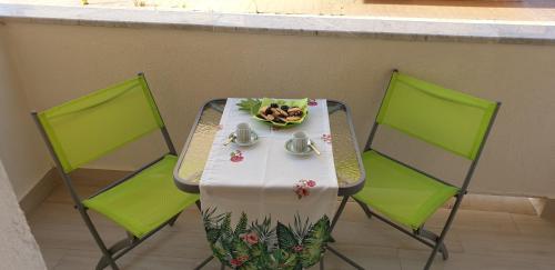 a table with two chairs and a plate of food on it at ele&gio accomodation in Tropea