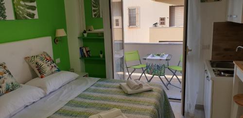 a green room with a bed and a table and chairs at ele&gio accomodation in Tropea