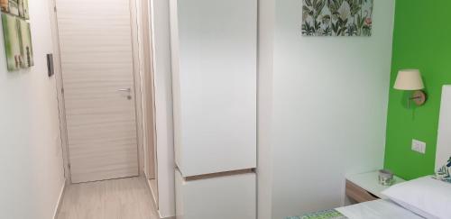 a bedroom with a white door and a green wall at ele&gio accomodation in Tropea