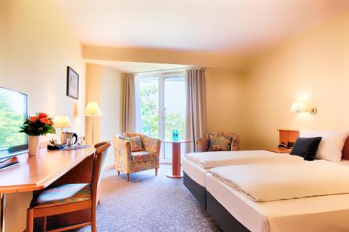 a hotel room with a bed and a desk at ACHAT Hotel Bad Dürkheim in Bad Dürkheim