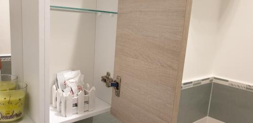 a door to a bathroom with a shelf with toiletries at ele&gio accomodation in Tropea
