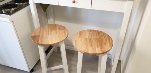 two wooden stools sitting next to a kitchen counter at ele&gio accomodation in Tropea
