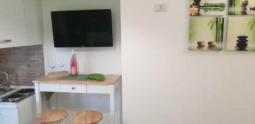 a kitchen with a table with a tv on a wall at ele&gio accomodation in Tropea