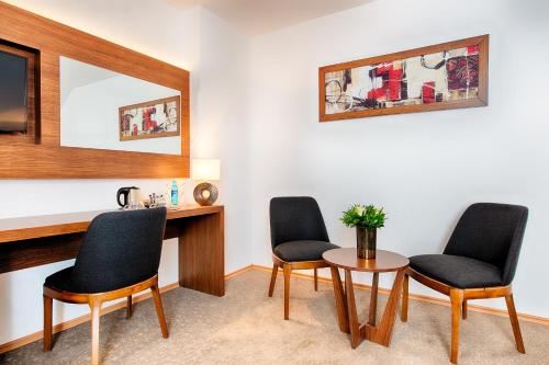 a room with three chairs and a table and a mirror at ACHAT Hotel Bad Dürkheim in Bad Dürkheim