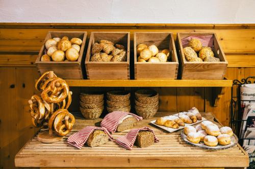 a shelf filled with different types of bread and pastries at Boutique-Hotel Bayerischer Hof in Kempten