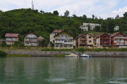 a group of houses on the side of a river at Apartments Sokolović in Višegrad