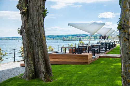 a row of tables and chairs with umbrellas at Steigenberger Inselhotel in Konstanz