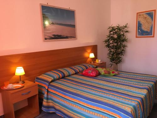 ein Schlafzimmer mit einem Bett, zwei Lampen und einer Anlage in der Unterkunft SAMARCANDA camere e appartamenti in Porto Cesareo