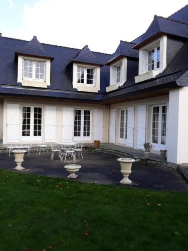 a house with a lot of chairs in the yard at Chambre belle demeure in Gouesnou