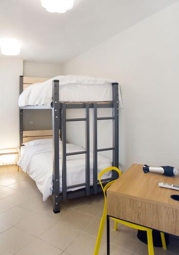 a room with a bunk bed with a desk and a tableablishthritisthritisthritis at Snooze H in Athens