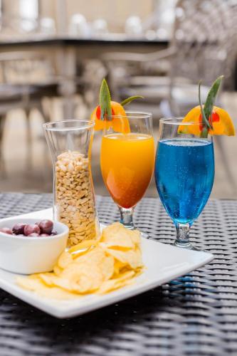 a table with a plate of food and two drinks at Premier Hotel Cape Town in Cape Town