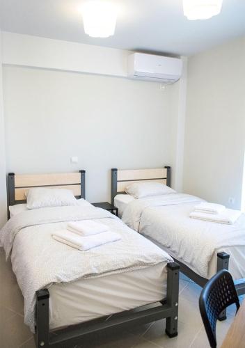 two beds in a room with white walls at Snooze H in Athens