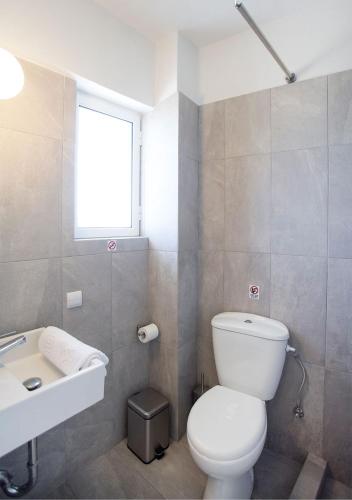 a bathroom with a white toilet and a sink at Snooze H in Athens
