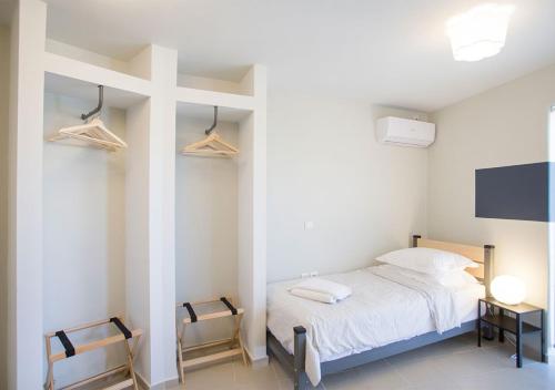a bedroom with a bed and a tv and two chairs at Snooze H in Athens