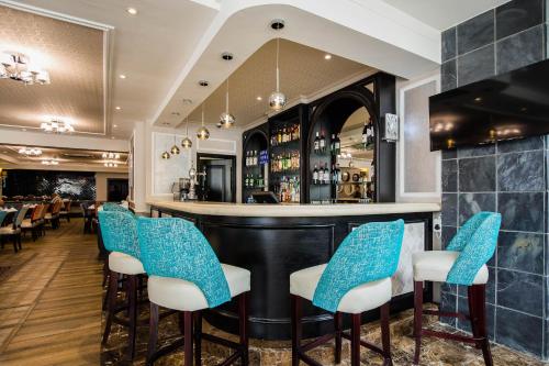 a bar with blue chairs in a restaurant at Premier Hotel Cape Town in Cape Town