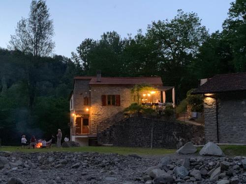 a stone house with a fire in front of it at Magic Mill Castagnetoli in Mulazzo