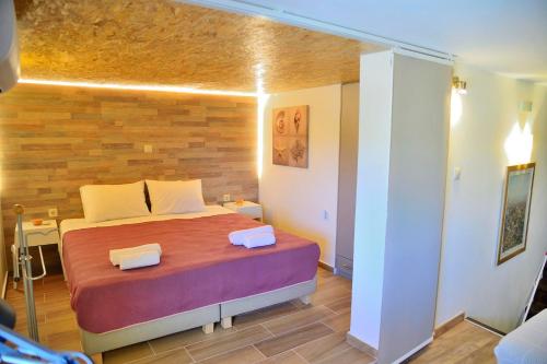 a bedroom with a bed with a wooden wall at Balcony Rooms in Elafonisi
