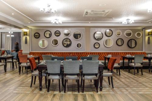 a dining room with tables and chairs and a wall of mirrors at Premier Hotel Cape Town in Cape Town