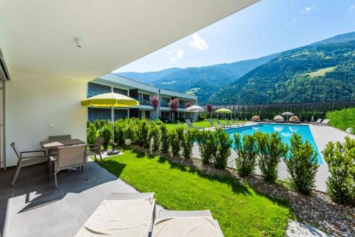 an indoor patio with a view of a pool and mountains at Residence & Sportlodges Claudia in Plaus