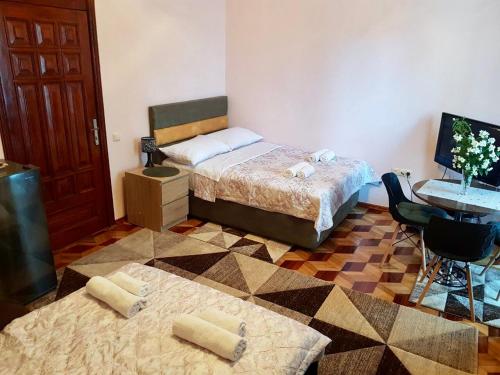 a bedroom with two beds and a desk with a computer at Sweet Home at Ninoshvili 3 in Batumi