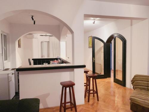 a kitchen and living room with a counter and stools at Hostel Holiday Cetinje in Cetinje