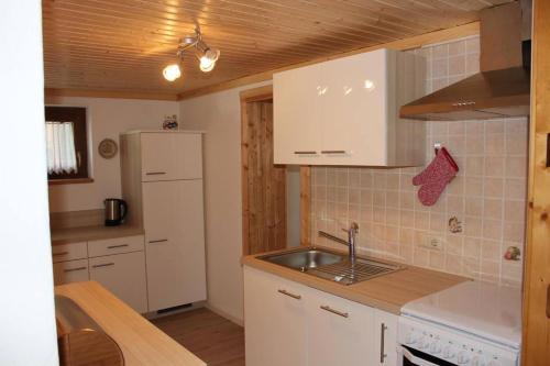 a kitchen with a sink and a white refrigerator at Haus Julia in Bad Kleinkirchheim