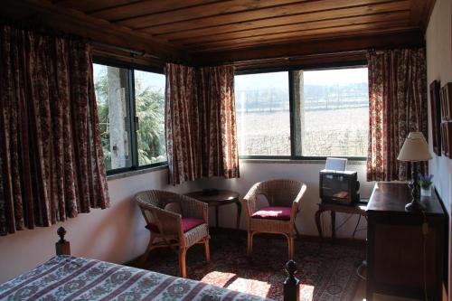 a bedroom with a bed and two chairs and a desk at Quinta de S.Vicente in Geraz do Minho