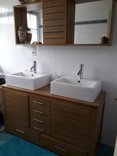 twee wastafels op een houten aanrecht in een badkamer bij Chambre belle demeure in Gouesnou