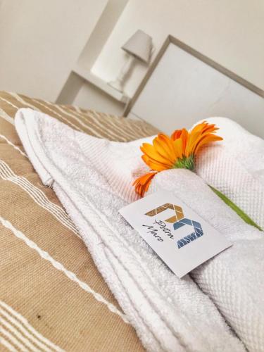 a white towel with a flower on top of a bed at PETRAMARE in Cursi