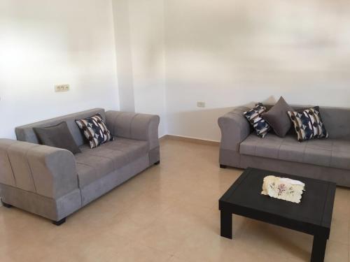 a living room with two couches and a coffee table at Belle Vue de Mer in Tazarka