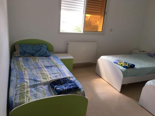 a bedroom with two beds and a window at Belle Vue de Mer in Tazarka
