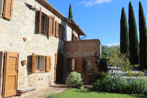 an old stone house with trees in front of it at Villa Porsenna in Chiusi