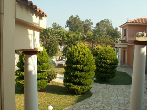 a row of trees in a yard next to a building at Elanthi Village Apartments in Kalamaki