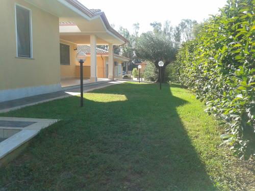 a yard with two parking meters in front of a house at Hotel Villa Aurora in Latina