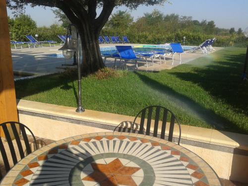 a table with an umbrella and chairs and a pool at Hotel Villa Aurora in Latina