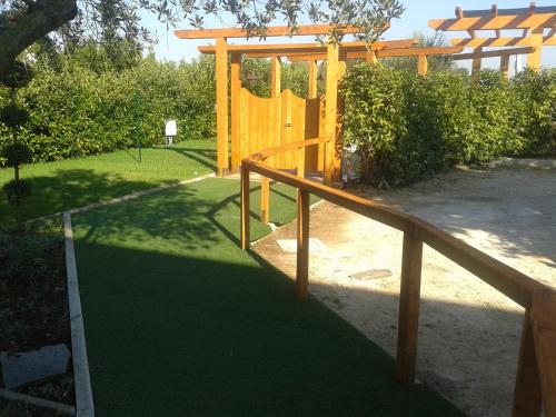 a wooden playground with a wooden railing in a yard at Hotel Villa Aurora in Latina
