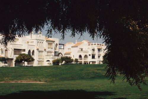 a large white building on a grass field at Apartamentos Golf Center in Roquetas de Mar