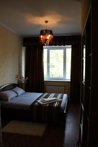 a bedroom with a bed and a window and a chandelier at Hotel Meduza in Kharkiv