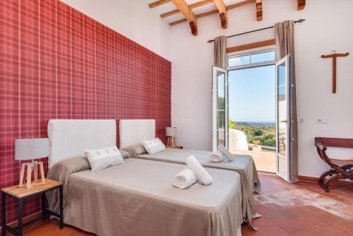 a bedroom with two beds and a large window at Finca Son Pere in Ferreries