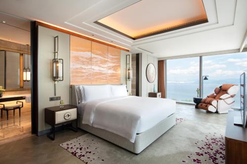 a bedroom with a large white bed and a desk at Raffles Shenzhen, Situated in the heart of One Shenzhen Bay, Book Now to Enjoy Free Minibar and Happy Hour Privileges at Long Bar on 71F in Shenzhen